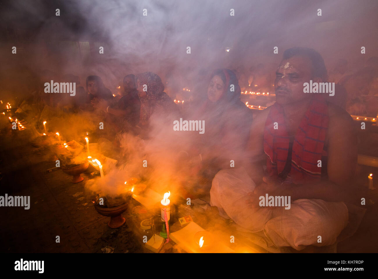 Dhaka, Bangladesch. 14. November 2017. Anhänger besuchen Gebet mit Räucherstäbchen und leichte Öl-Lampen vor dem Fasten während ein religiöses Fest am 14. November 2017 genannten Rakher Upabash in der Nähe von Dhaka. Bengalischen Volkes des hinduistischen Glaubens in Bangladesch sitzen im Gebet zur Feier des 18. Jahrhunderts hinduistischen heiligen Baba Lokenath mit einem 'Rakher Upobas "Gebet und Fasten Tag jedes Jahr Tausende von hinduistischen Gläubigen vor Shri Shri Lokenath Brahmachari Ashram Tempel für die Rakher Upobash religiöses Fest in Barodi sammeln, in der Nähe von Dhaka, Bangladesch. Credit: Azim Khan Ronnie/Alamy leben Nachrichten Stockfoto Dhaka, Bangladesch. 14. November 2017. Anhänger besuchen Gebet mit Räucherstäbchen und leichte Öl-Lampen vor dem Fasten während ein religiöses Fest am 14. November 2017 genannten Rakher Upabash in der Nähe von Dhaka. Bengalischen Volkes des hinduistischen Glaubens in Bangladesch sitzen im Gebet zur Feier des 18. Jahrhunderts hinduistischen heiligen Baba Lokenath mit einem 'Rakher Upobas "Gebet und Fasten Tag jedes Jahr Tausende von hinduistischen Gläubigen vor Shri Shri Lokenath Brahmachari Ashram Tempel für die Rakher Upobash religiöses Fest in Barodi sammeln, in der Nähe von Dhaka, Bangladesch. Credit: Azim Khan Ronnie/Alamy leben Nachrichten Stockfoto