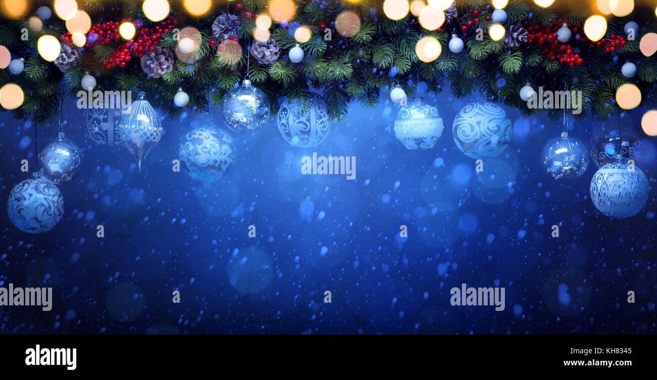 Kunst Weihnachten Dekoration; Tannenzweigen und weißen Christbaumkugel auf Blau snowy Hintergrund Stockfoto
