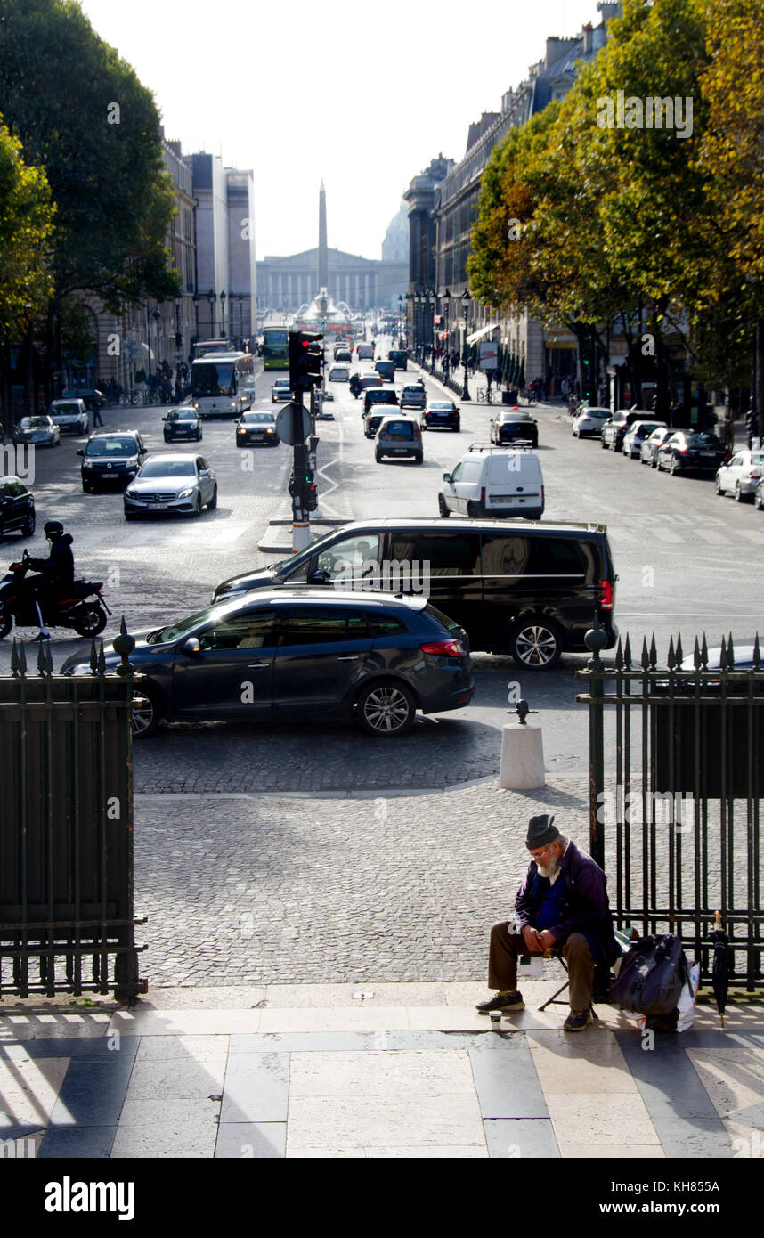 Paris, Frankreich. Obdachloser am Gate La Madelaine Kirche betteln, Place de La Madelaine - Place de la Concorde in der Ferne Stockfoto