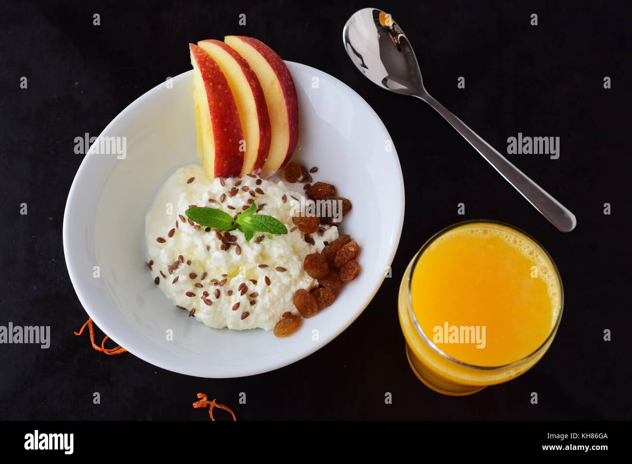 Gesundes Frühstück: Quark mit Leinsamen, Rosinen, frische Äpfel und ein Glas frisch gepresster Orangensaft. gesunde Ernährung Konzept Stockfoto