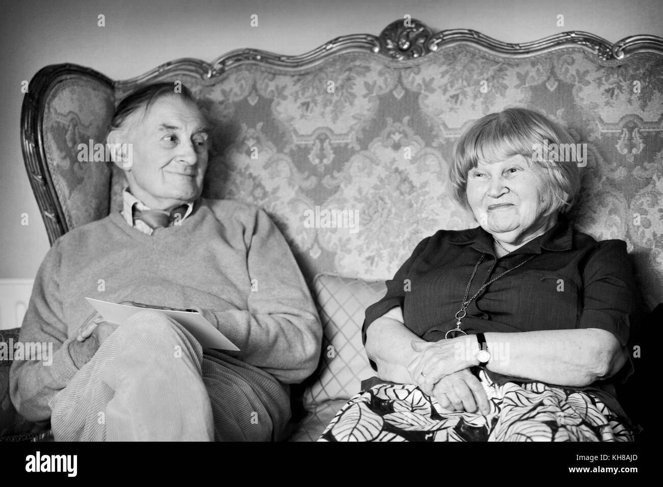 Fotograf Jane Bown (13. März 1925 - 21. Dezember 2014) und Karikaturist/illustrator Haro Hodson, B&W portrait Sitzen auf einem Sofa Stockfoto