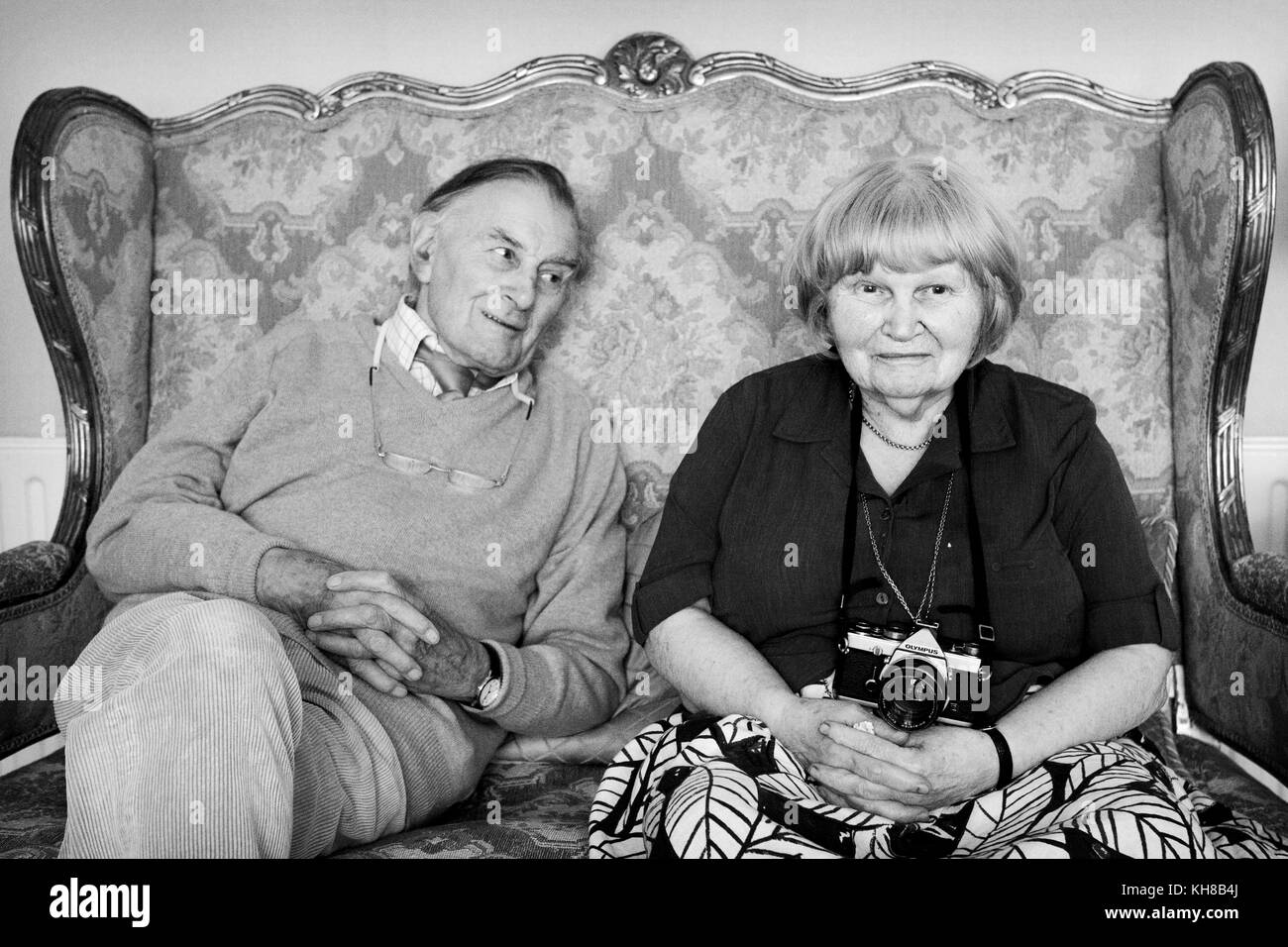 Fotograf Jane Bown (13. März 1925 - 21. Dezember 2014) und Karikaturist/illustrator Haro Hodson, B&W portrait Sitzen auf einem Sofa Stockfoto