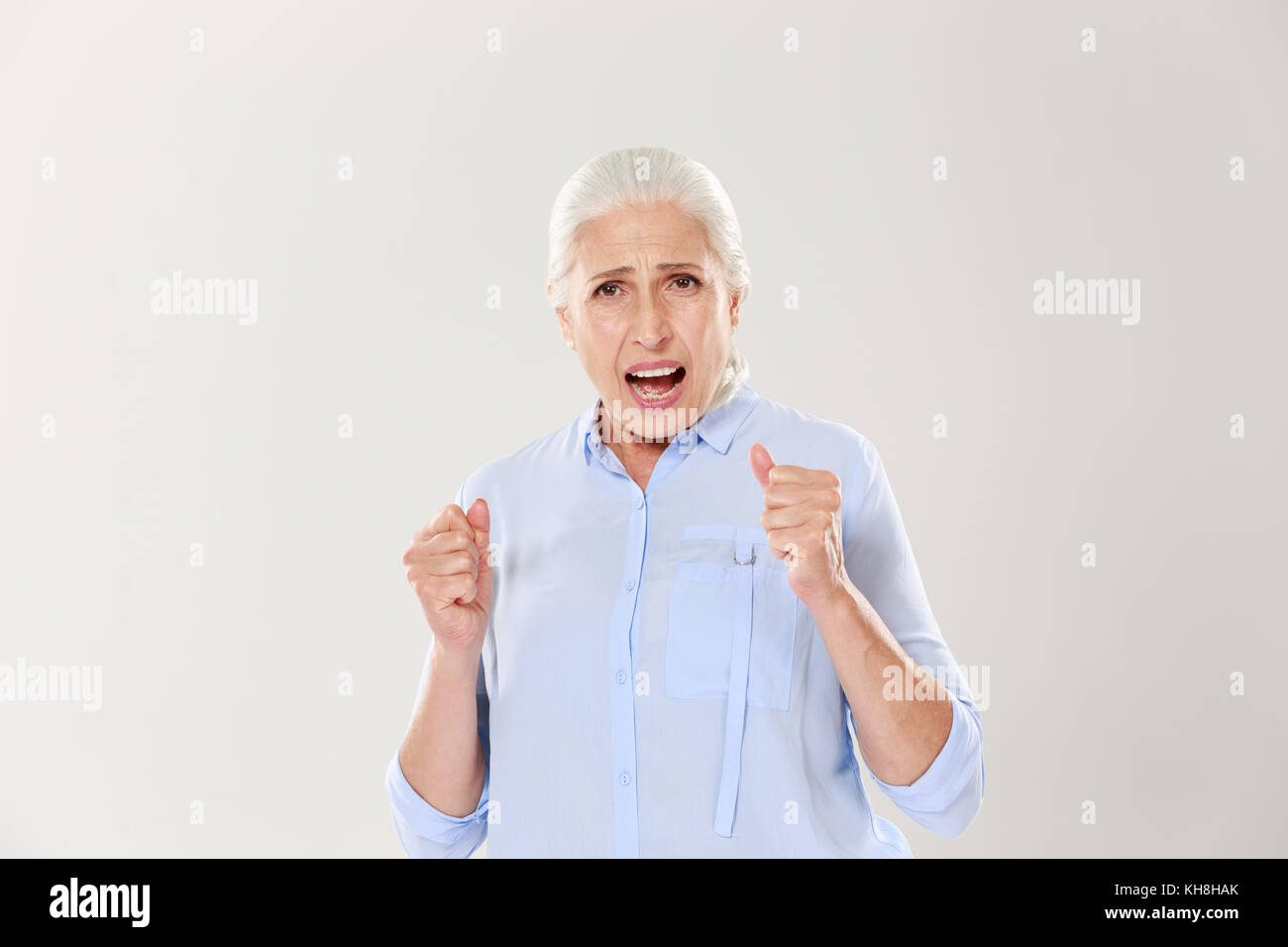 Foto der freudigen ältere Frau etwas Unterstützung, von der Kamera suchen, auf weißem Hintergrund Stockfoto