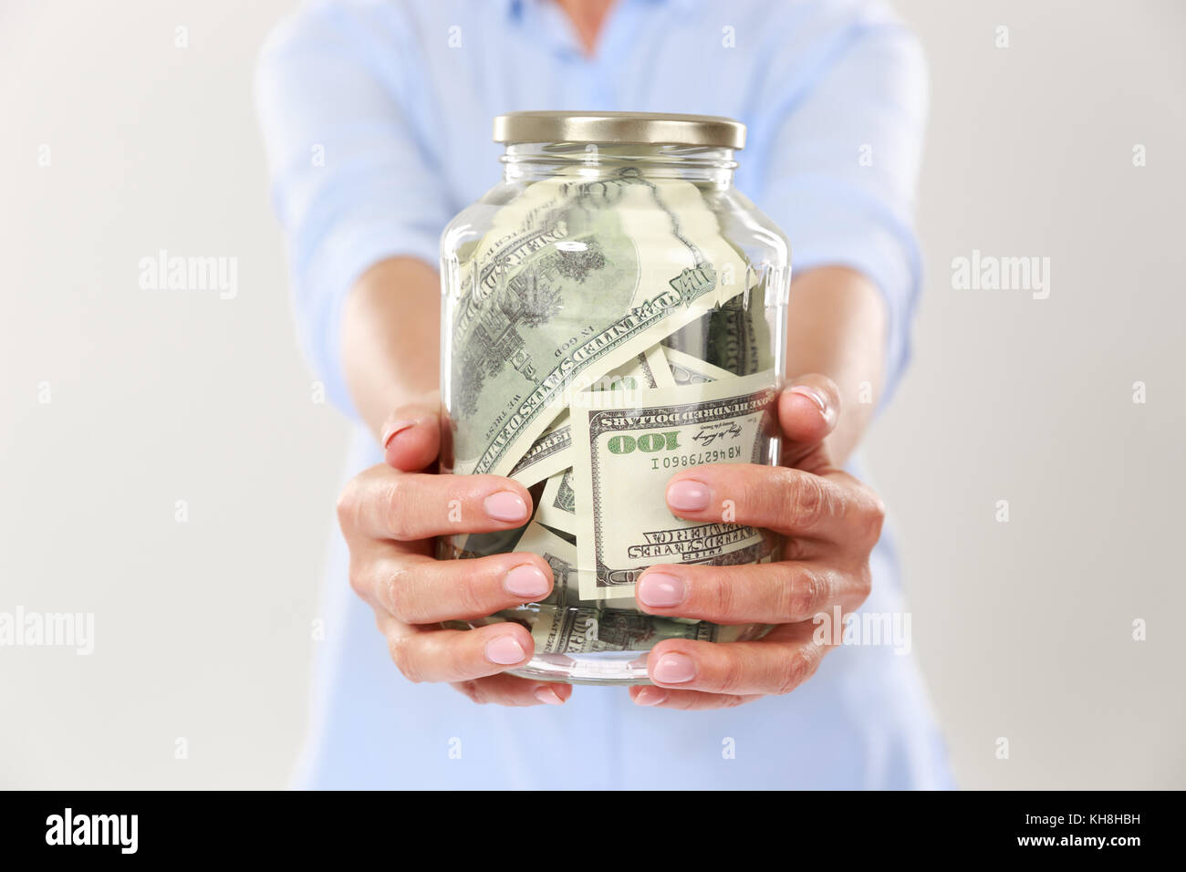 Foto von womans Hände halten Glas Glas mit Dollarscheine, auf weißem Hintergrund 7/8 Stockfoto