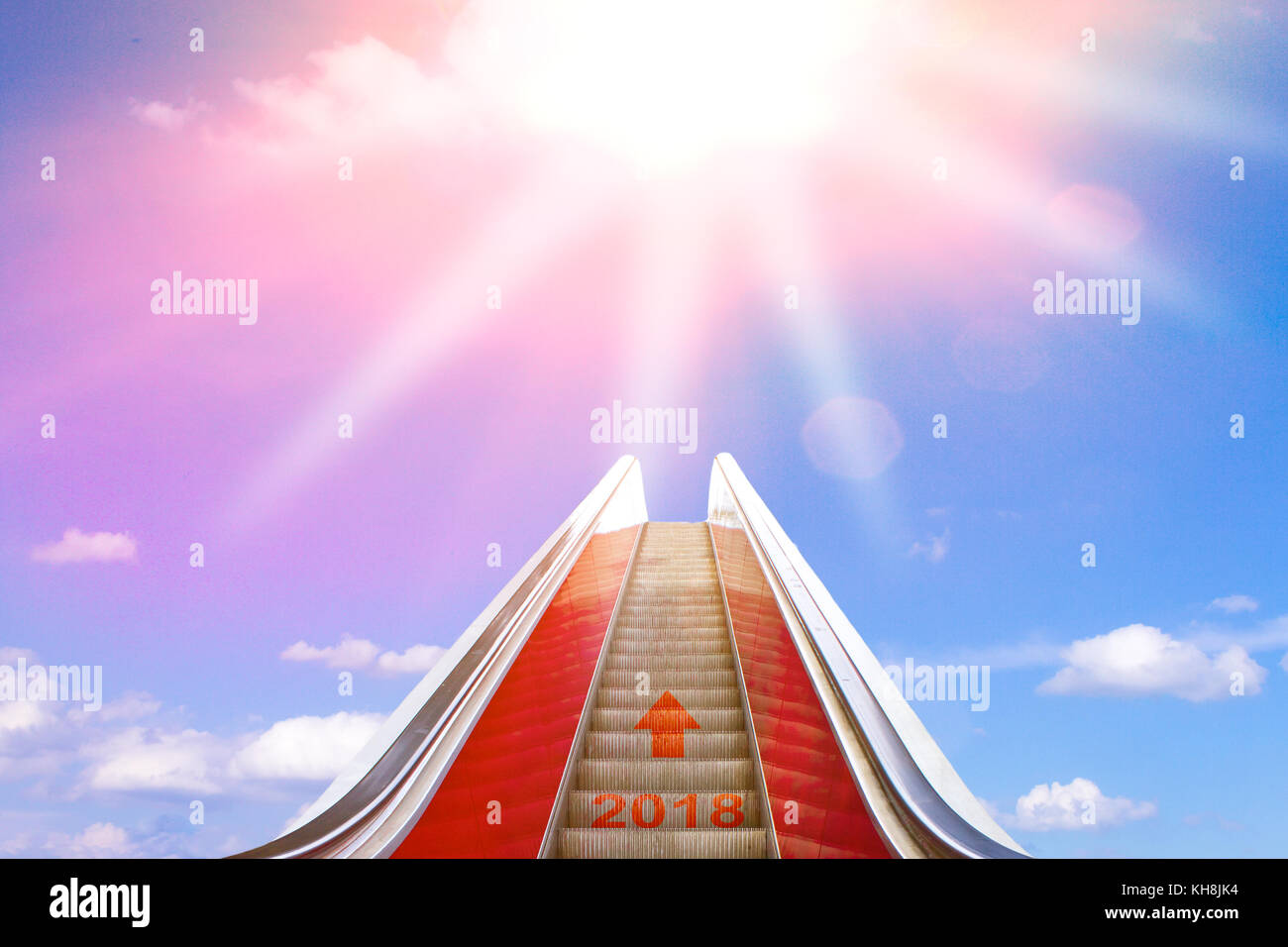 Aufsteigend auf einer Rolltreppe mit einem Pfeil und 2018 in Sonnenlicht geschrieben. Konzept Foto für ein erfolgreiches neues Jahr und eine helle Zukunft. Stockfoto