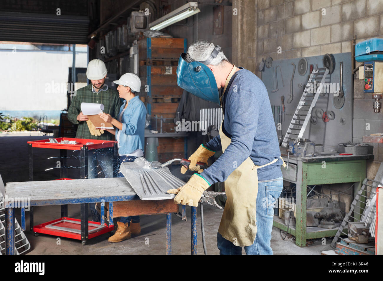 Schweißer oder metallbauer mit Schutzkleidung in der Werkstatt Stockfoto