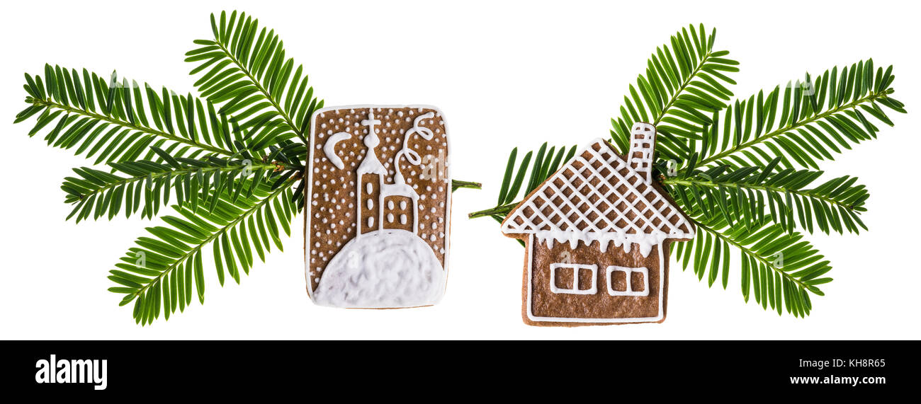 Zwei wunderschöne Weihnachtsdekorationen mit traditionellen handgemachten Lebkuchen. Prunkvoll verzierte grüne Zweige mit Haus und Kirche auf weißem Hintergrund. Stockfoto
