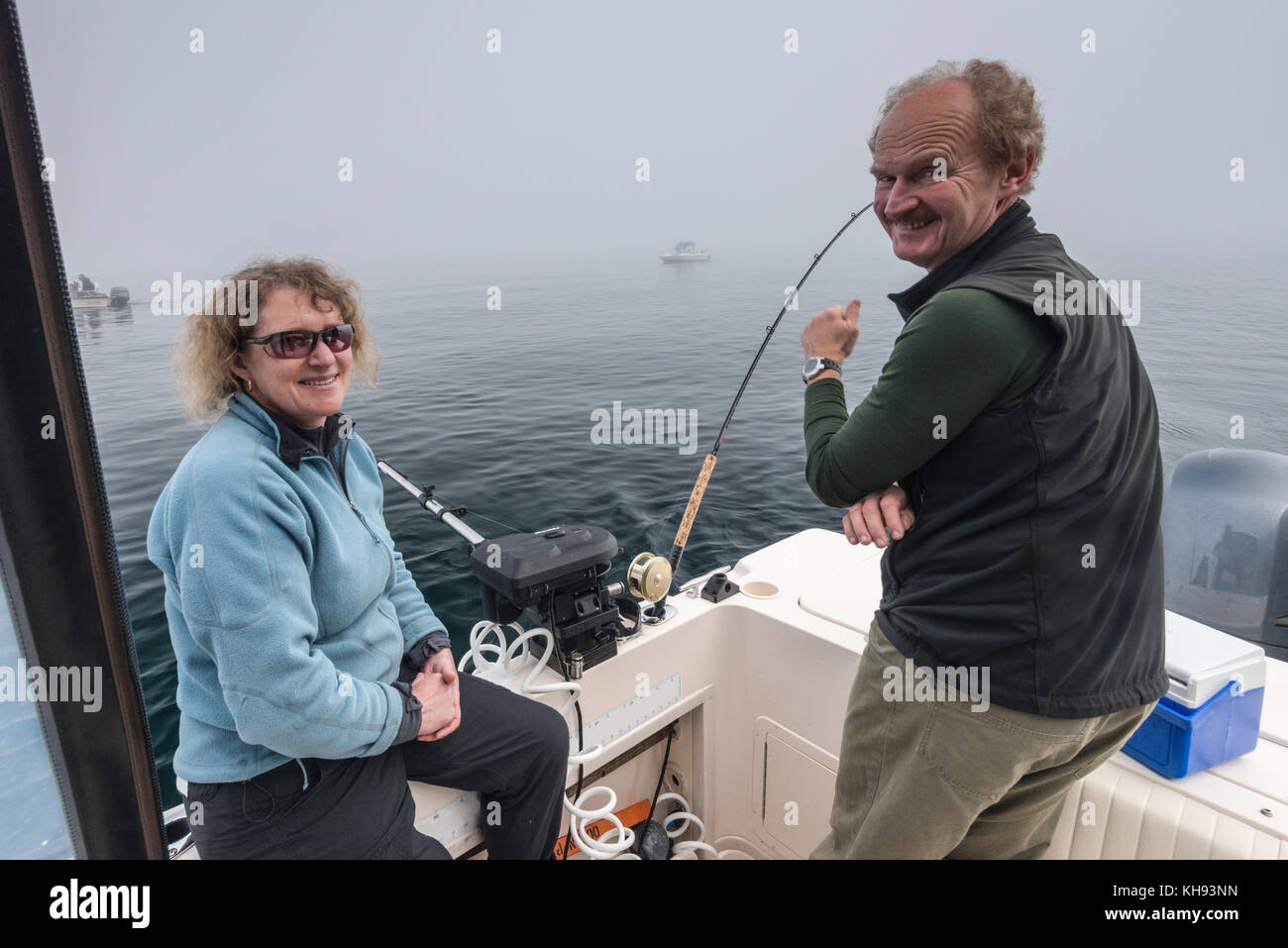 Erwachsene mittleren Alters mit Angelrute, auf Fischerboot, nebeliger Morgen in der Johnstone Strait vor Vancouver Island, British Columbia, Kanada Stockfoto