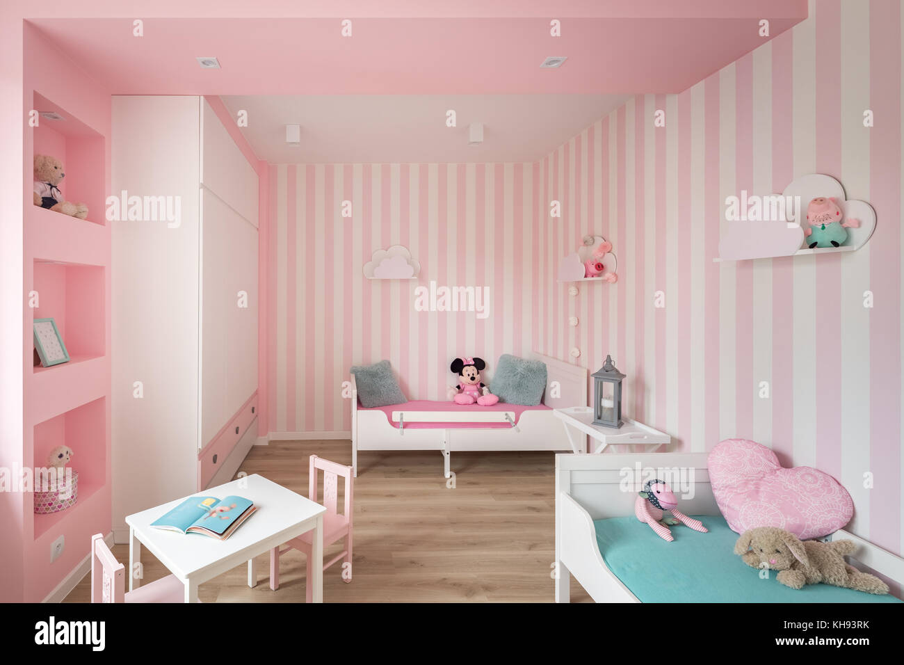 Rosa Zimmer mit gestreiften Wänden und weißen Möbeln Stockfoto, Bild