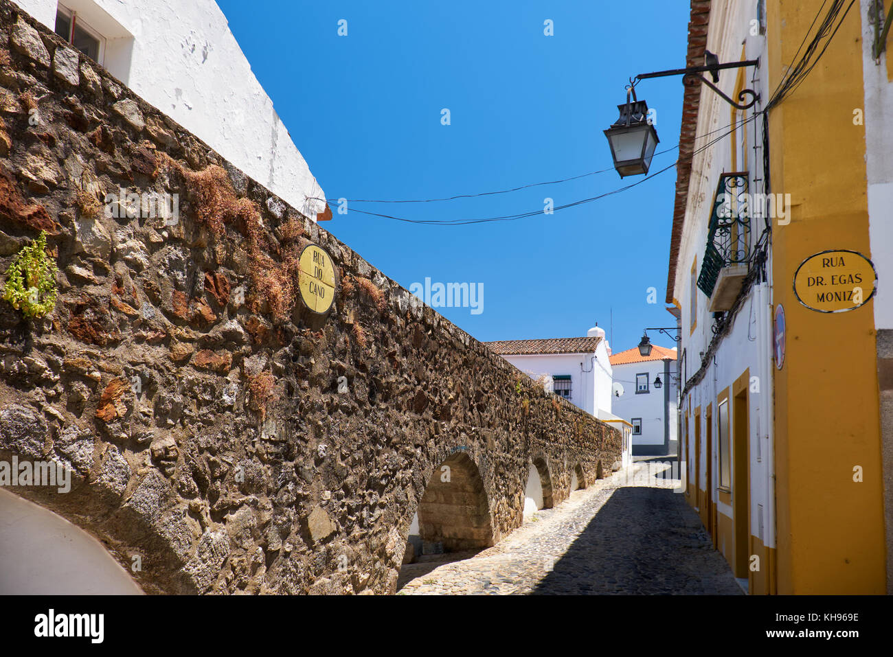 Die Bögen des Aquädukts von Silber Wasser (prata Aquädukt) senkt und sich mit Geschäften und Häusern umgeben, wie sie Portugal Evora eingeben. Stockfoto