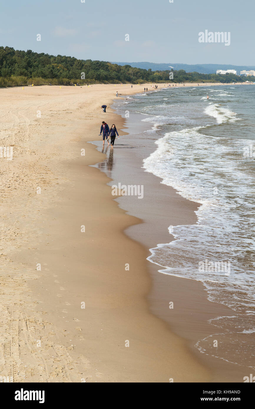 Blick auf wenige Leute an der brzezno Strand und Ostsee in Danzig, Polen flanieren, an einem sonnigen Tag im Herbst. Stockfoto