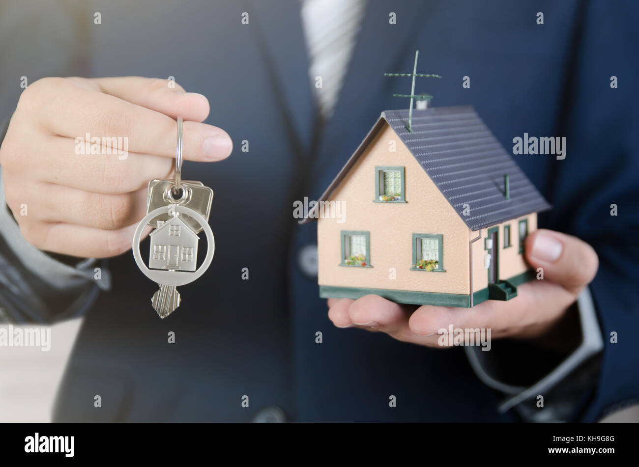Real estate agent mit home Schlüssel und Haus Miniatur. Untertyp der Schlüssel apartment Immobilien Home Haus Hausbesitzer Konzept Stockfoto