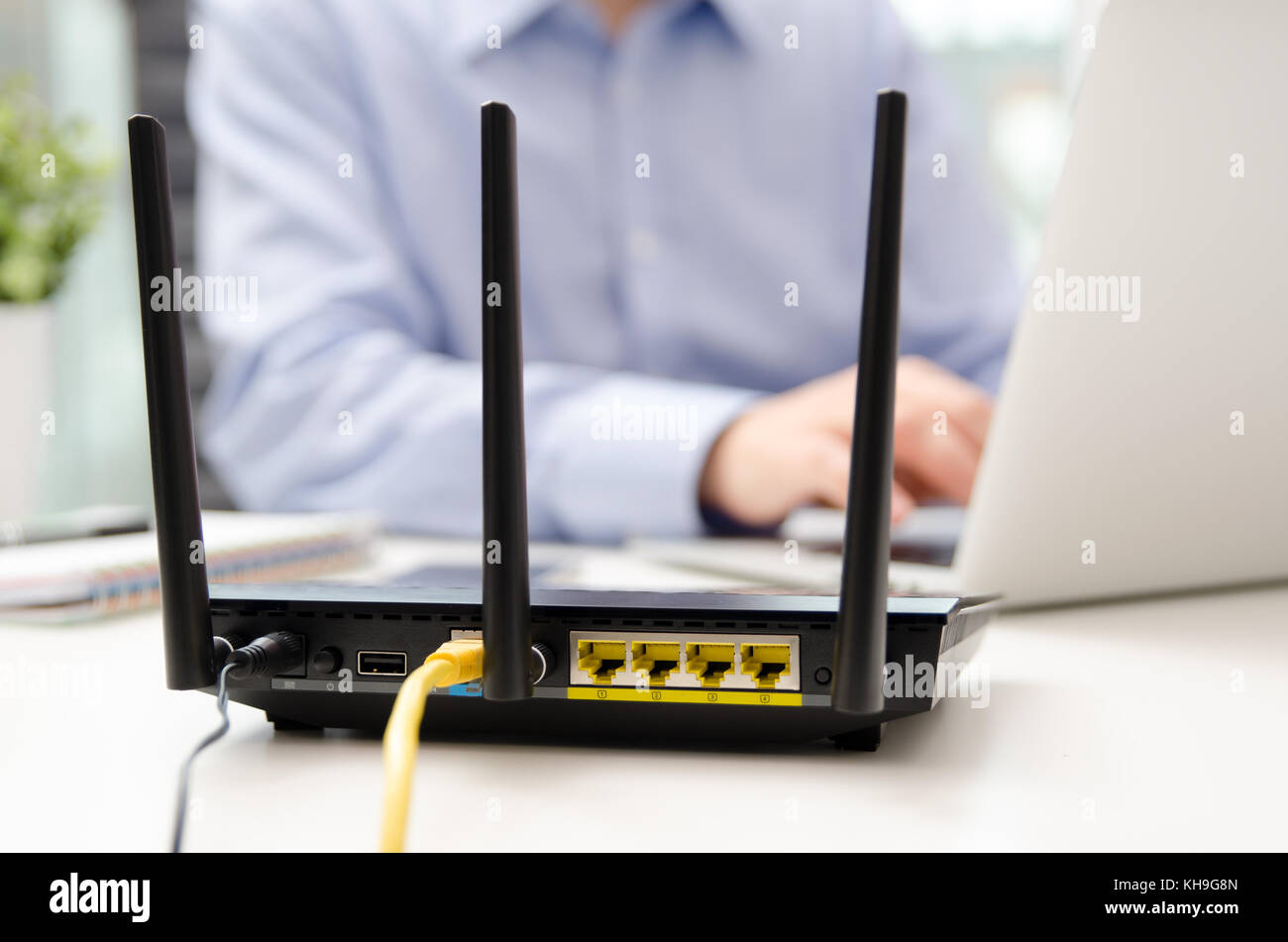 Wireless Router und mit einem Laptop im Büro Mann. Router Wireless Broadband home Laptop Telefon WLAN-Konzept Stockfoto