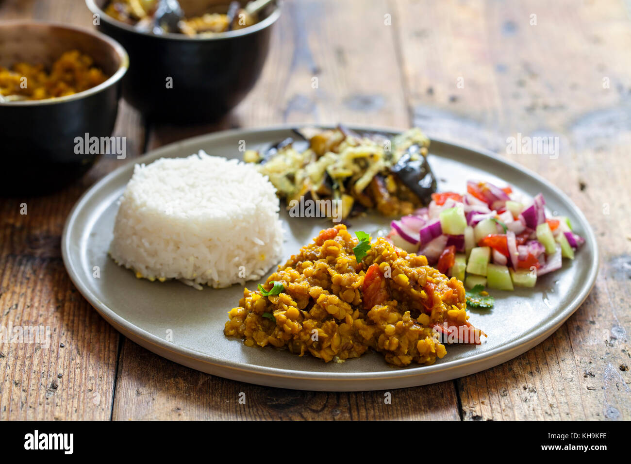 Indisches essen mit masoor Dal-Linse Curry, dahi baingan, Reis und Salat Stockfoto
