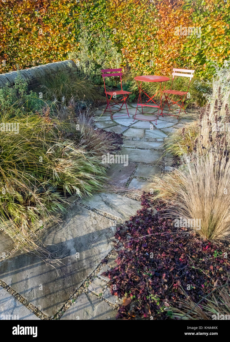 Kleiner Garten Terrasse mit Pflastersteine, Esstisch und Stühlen, und im Herbst Farbe Pflanzen, Laub, England, Großbritannien Stockfoto