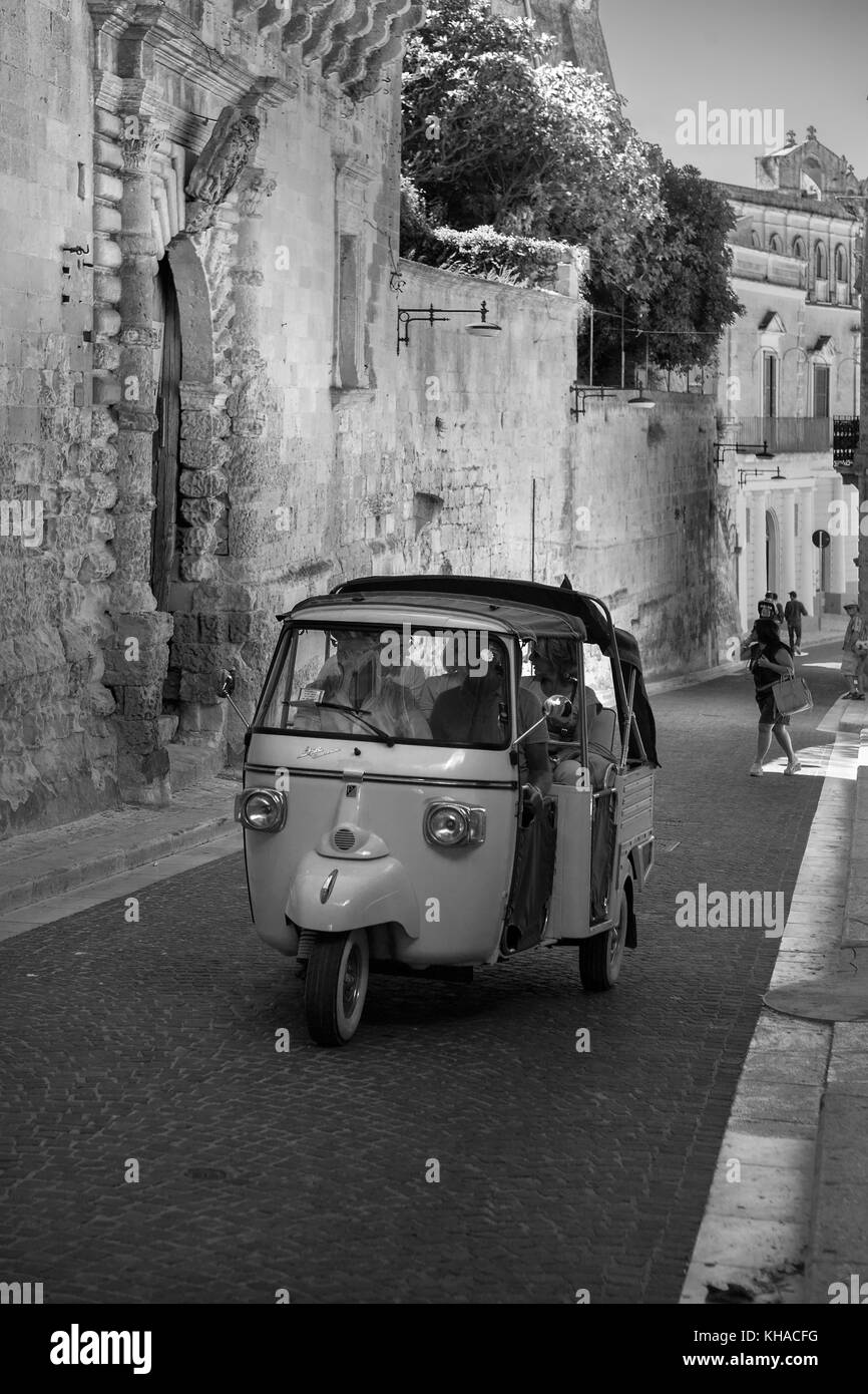 Piaggio 'Ape' 3-Rad-Taxi auf der Via Duomo in La Civita, Matera, Basilicata, Italien: Schwarz-weiß-Version Stockfoto