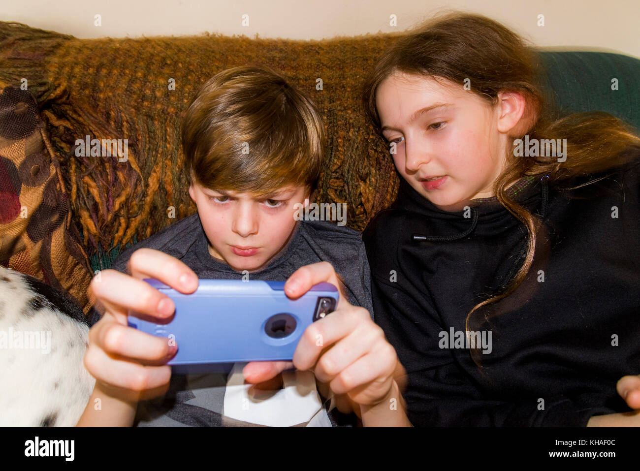 Jungen spielen auf dem Ipod mit der Otterbox-hülle Stockfoto