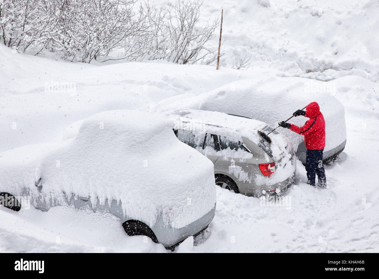 Jungen attraktiven Mann der Schnee Bürsten weg sein Auto an einem kalten Wintertag Stockfoto