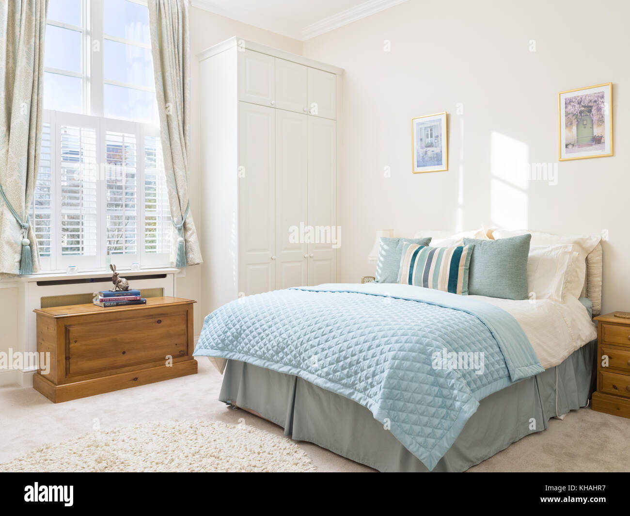 Eine frische, leichte, traditionelle und zugleich moderne Schlafzimmer mit einem großen Doppelbett, Kommode und Einbauschrank Stockfoto