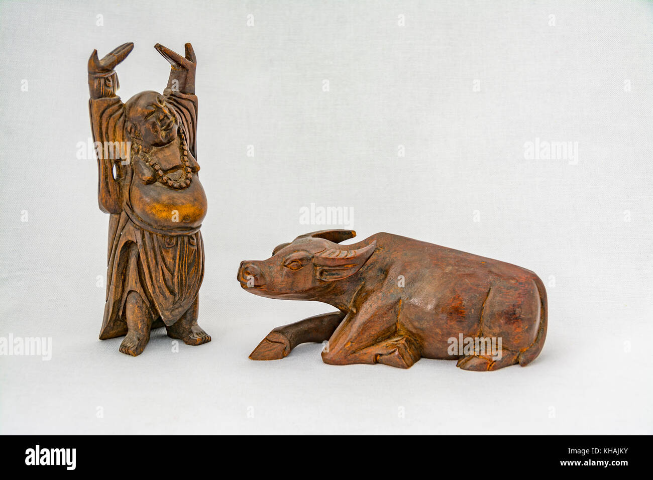 Holzschnitzereien mit einem lächelnden Buddha und eine heilige Kuh Symbole Stockfoto