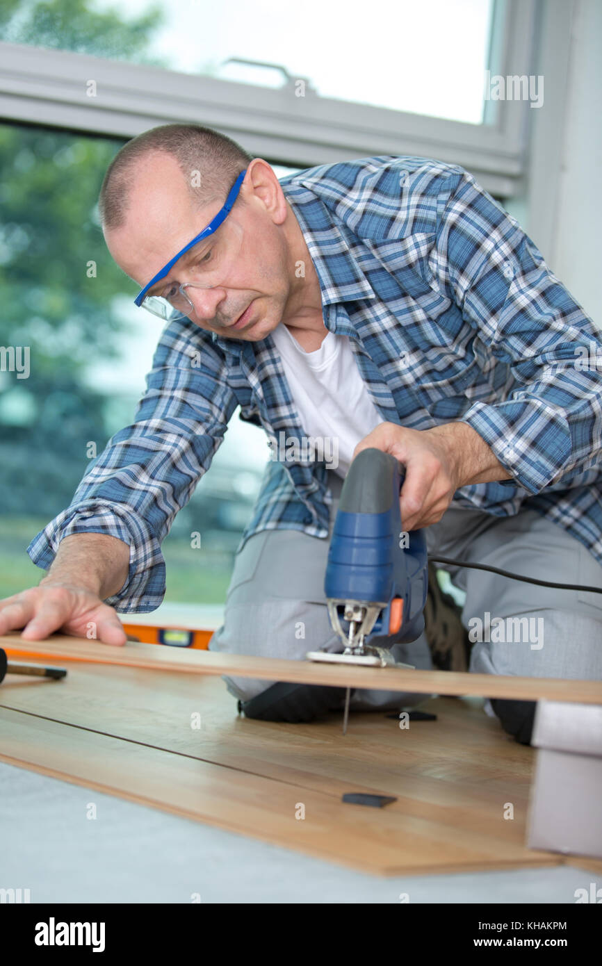 Stock setter Schneiden eine Planke mit einer Stichsäge Stockfoto