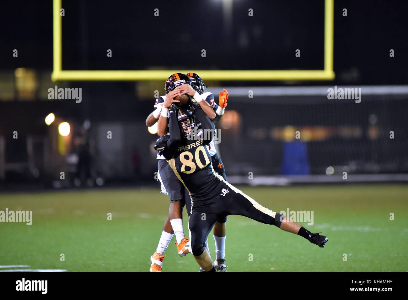 Während ein Fake ein Empfänger sichern einen Empfang für einen ersten Abstieg Punt trotz Bereitstellung einer Huckepack Fahrt für ein paar defensiven Rückseiten. USA. Stockfoto
