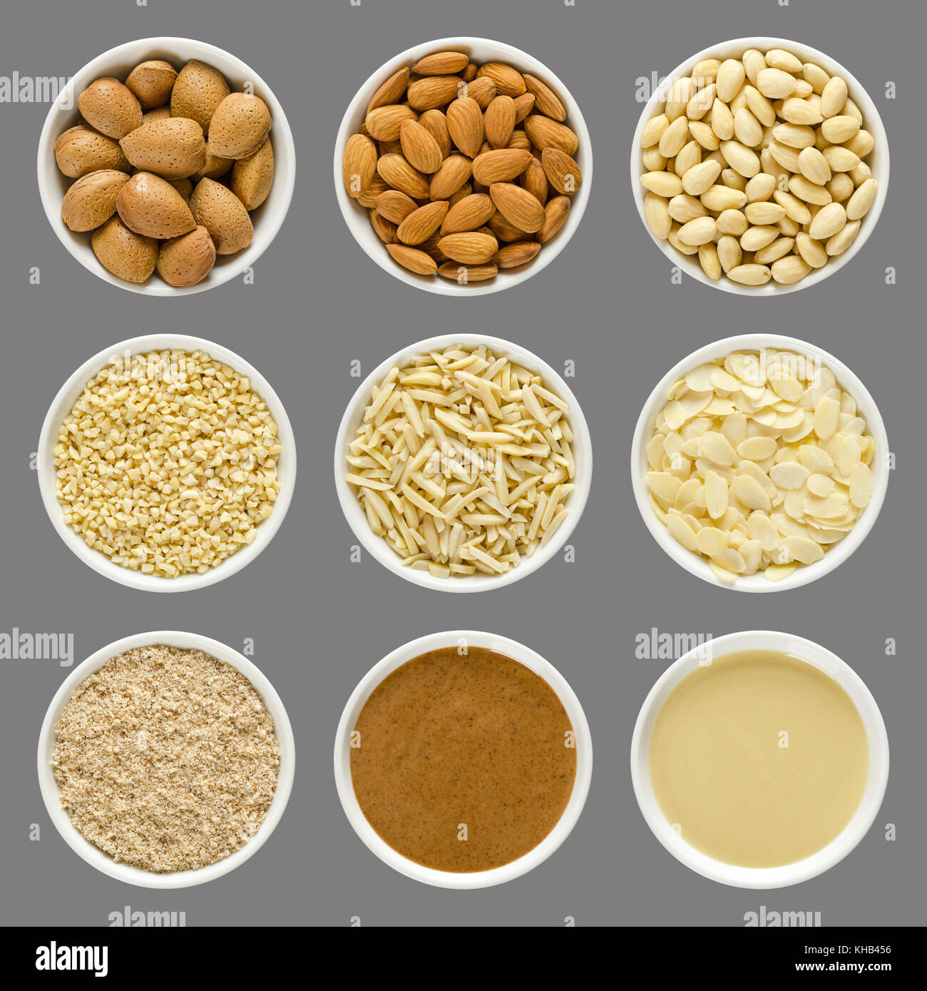 Mandeln in weißen Schalen über Grau. ganzen Nüssen mit Muscheln, geschält, blanchiert, gehackt, Slivered, geschnitten, gemahlen, braunen und weißen Mandeln Butter. Foto. Stockfoto