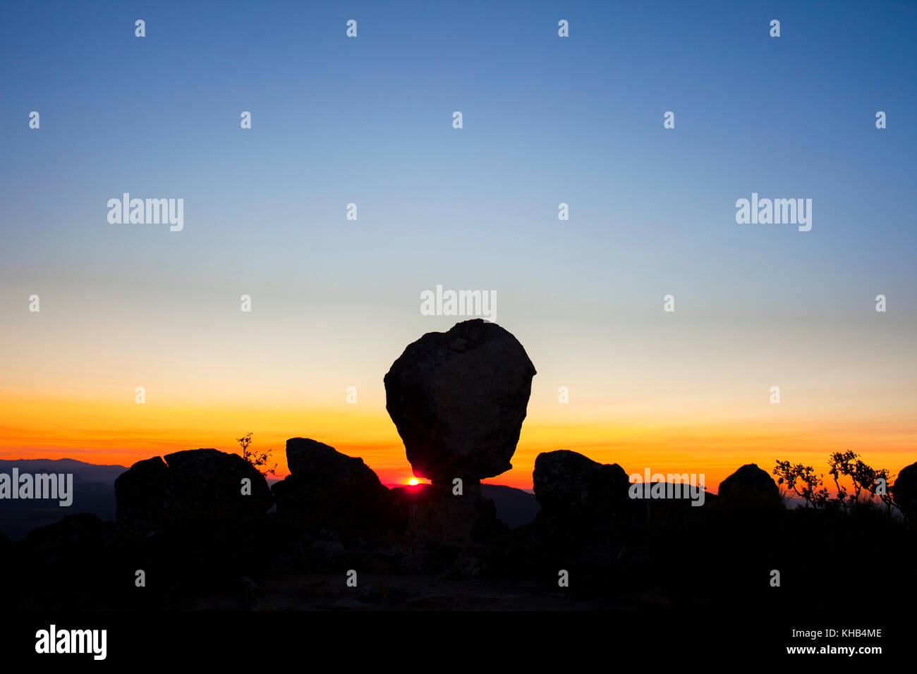 Sonne erscheint zwischen megalithischen Denkmal von Cancho Que SE Menea. In Englisch schüttelnd Rock. Montanchez, Spanien Stockfoto