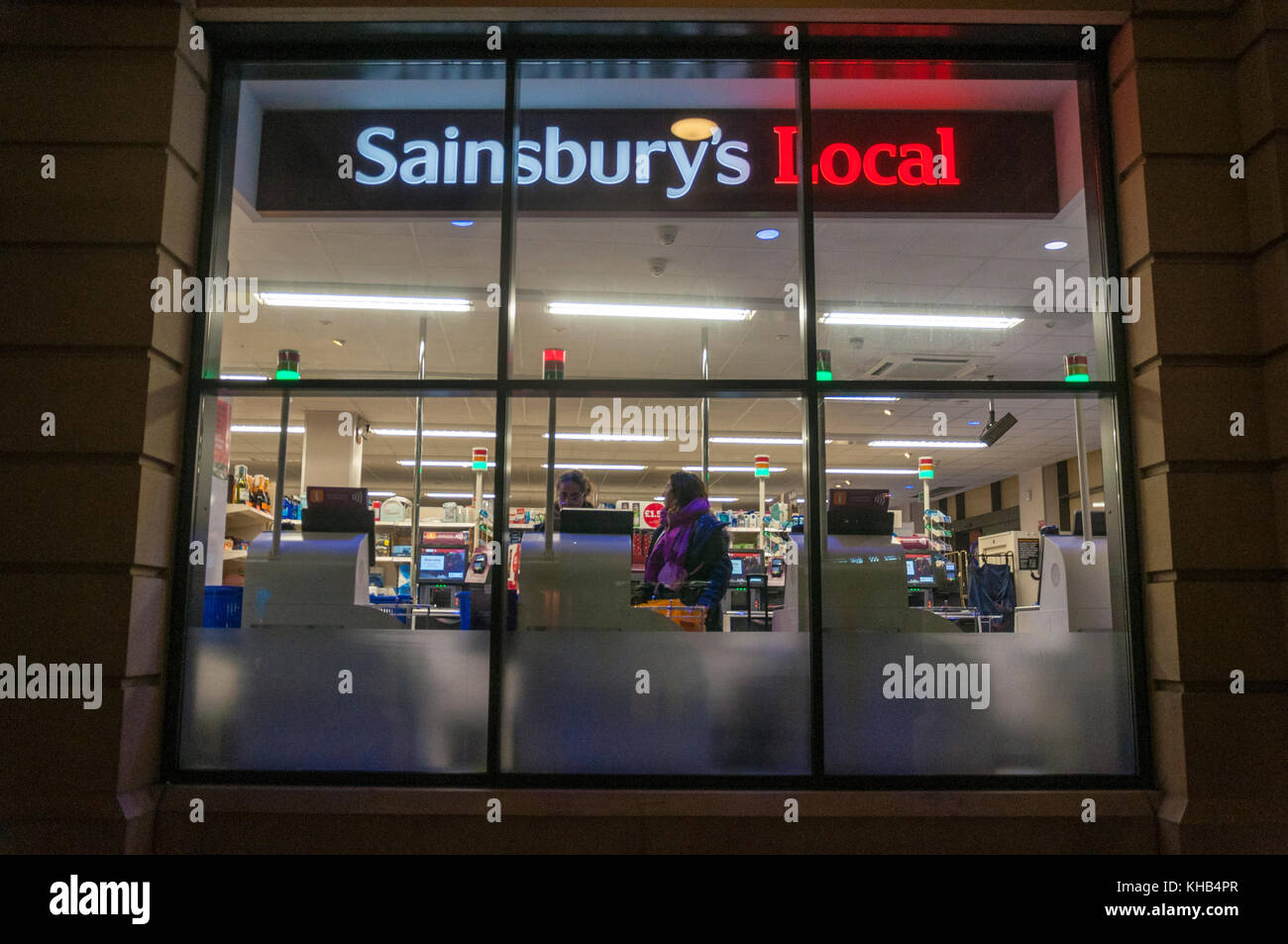 Blick durch das Fenster eines Sainsburys Lokale mit SB-Kassen Late night shopping in Bath, Großbritannien Stockfoto