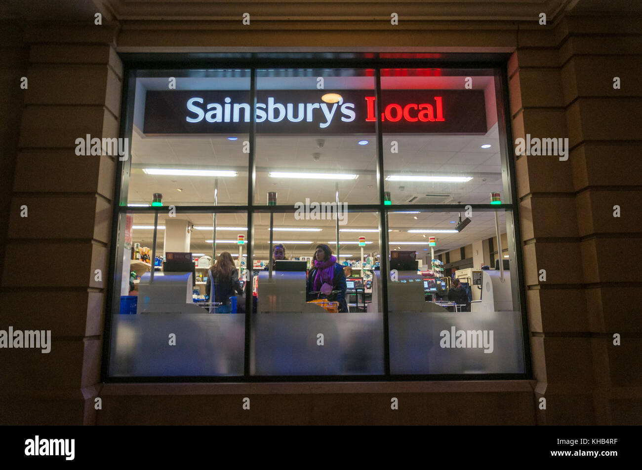 Blick durch das Fenster eines Sainsburys Lokale mit SB-Kassen Late night shopping in Bath, Großbritannien Stockfoto