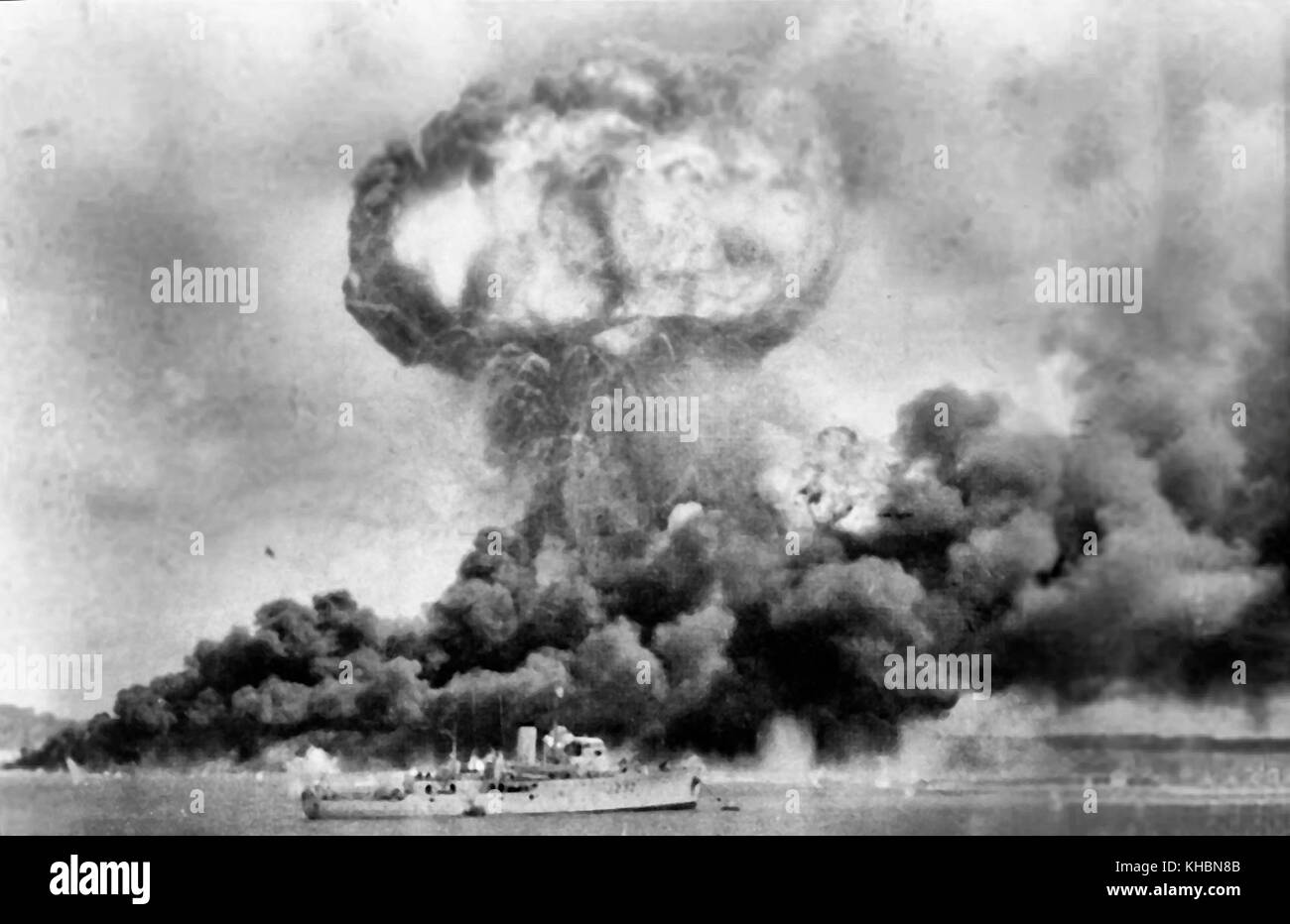 Die Explosion des MV Neptuna und Rauchwolken von Öltanks, während der ersten japanischen Luftangriff auf dem australischen Festland schlagen, in Darwin am 19. Februar 1942. Im Vordergrund ist hmas Deloraine, die Schäden zu entkommen. Datum 19. Februar 1942 Stockfoto