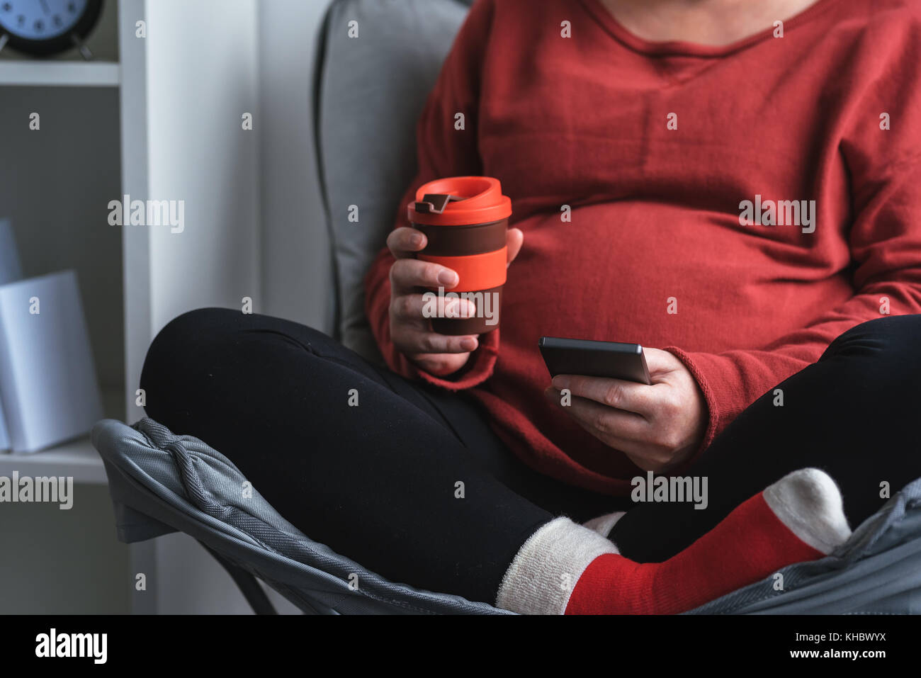 Entspannt schwangere Frau mit Smart Phone und Mobile App über Schwangerschaft und Mutterschaft zu informieren Stockfoto