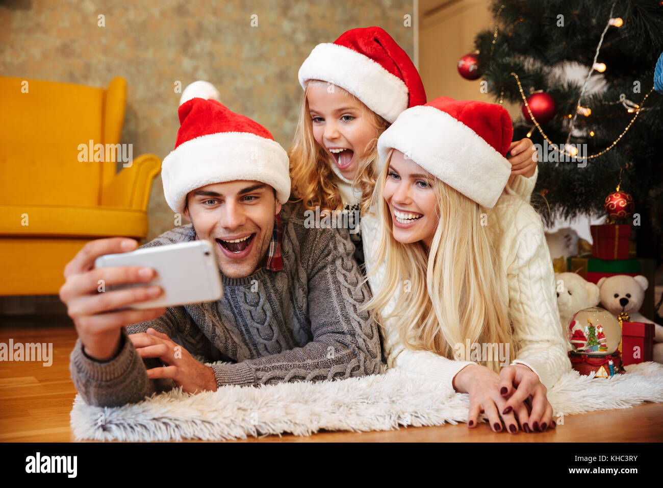 Lustig Schone Familie In Santa S Hut Nehmen Selfie Auf Handy Wahrend Auf Dem Boden Liegend In Der Nahe Von Weihnachten Baum Stockfotografie Alamy