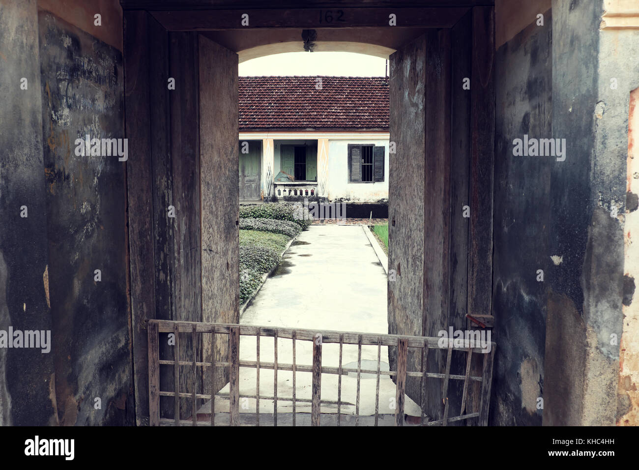 Vietnamesische altes Haus mit Holz Tür, Holz- Fenster und erstaunlich großen konkrete Tor, das alte Haus mit traditioneller Architektur am Tag, Vietnam Stockfoto