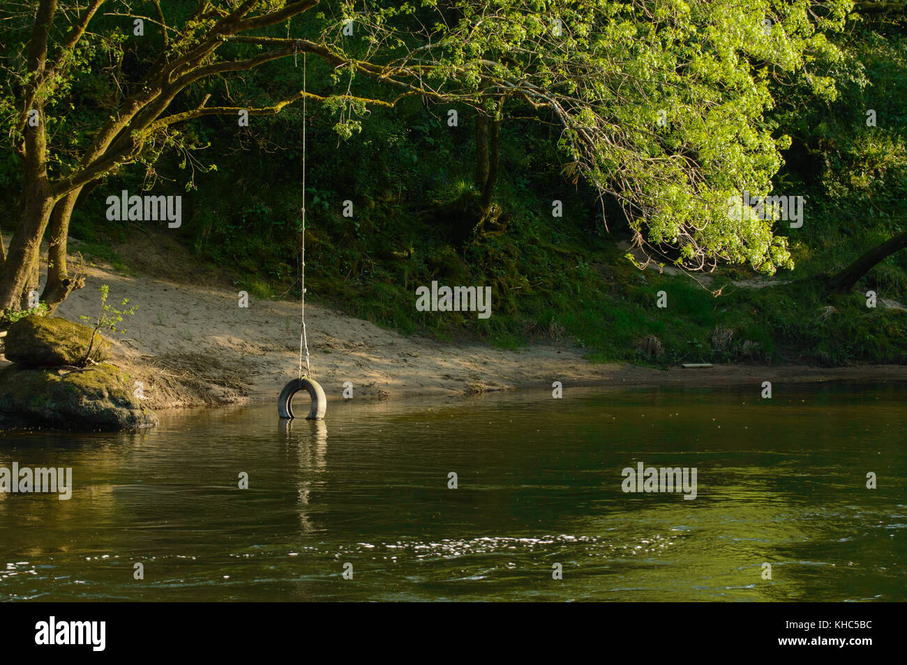 Ansicht schließen eines verlassenen Rad schwingen in den Fluss, während Wasser fließt um es. Unter Sonnenuntergang Licht aufgenommen. Stockfoto