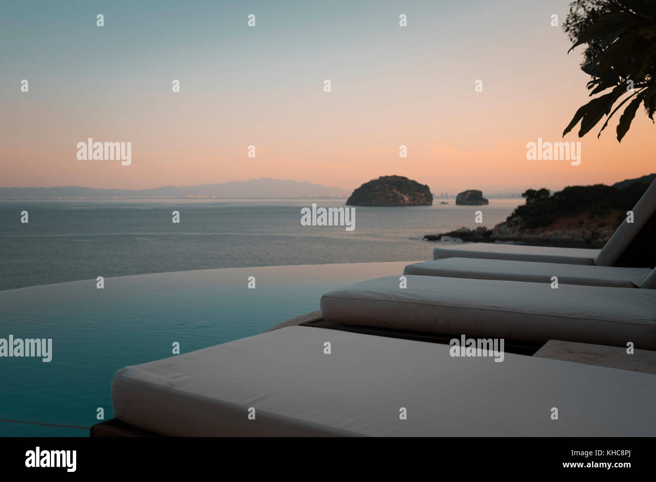 Nahaufnahme der Liegestühlen am Swimmingpool auf einer Terrasse direkt am Meer in MISMALOYA, Mexiko. Stockfoto