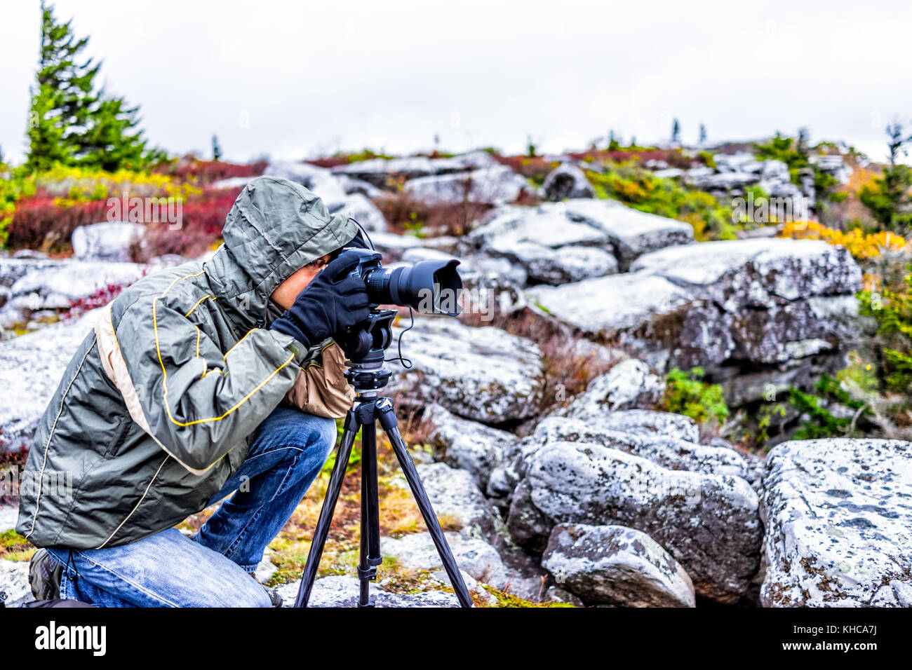 Junger Mann Fotograf mit Kamera und Stativ auf kalten Herbst Natur morgen in Jacke tragen, Felsen, West Virginia, die Bilder von Sunset Stockfoto