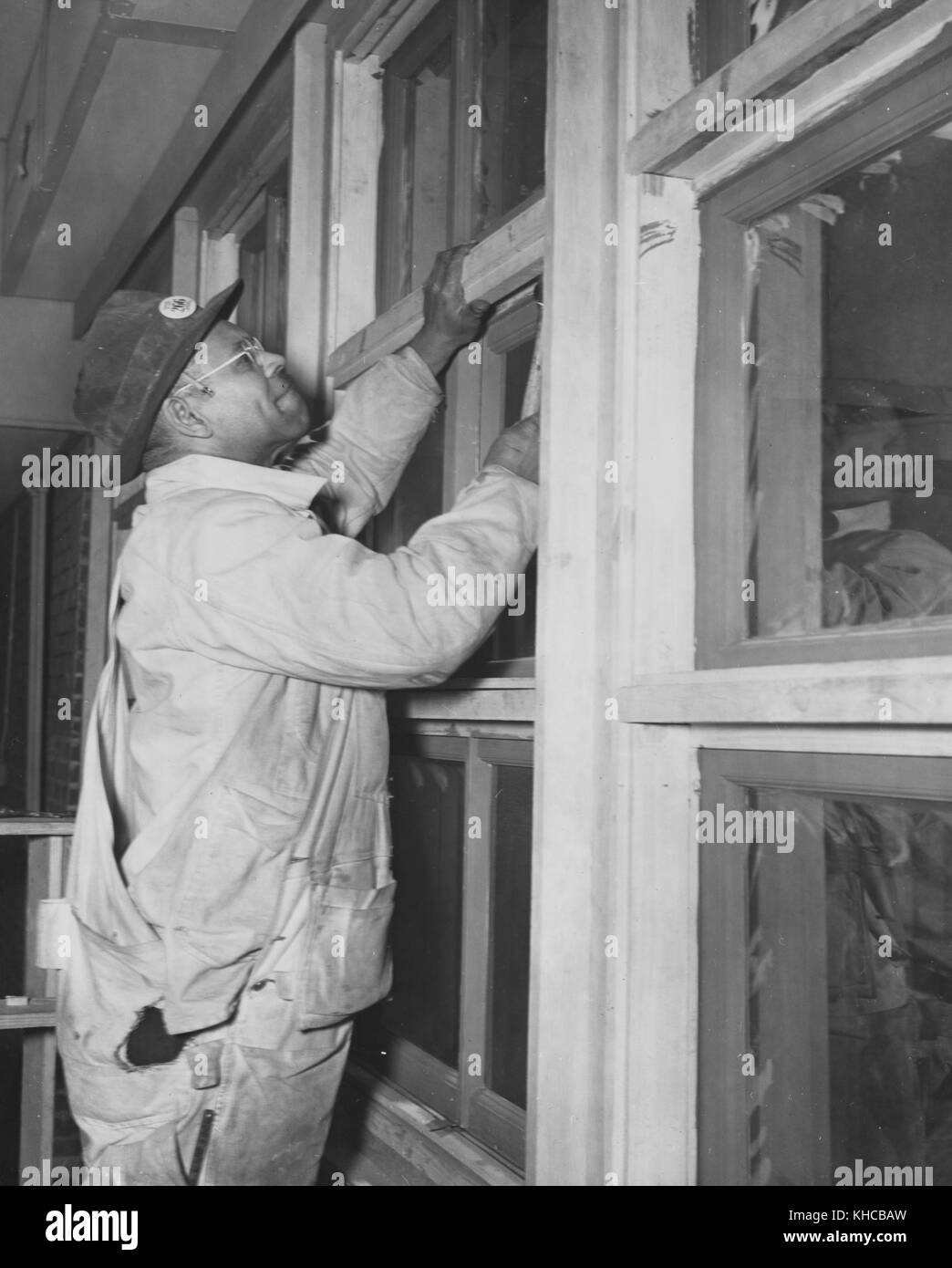 Afrikanische amerikanische Arbeiter Windows Installation als Teil des Krieges Wohnungsbauprogramms 1943. Von der New York Public Library. Stockfoto