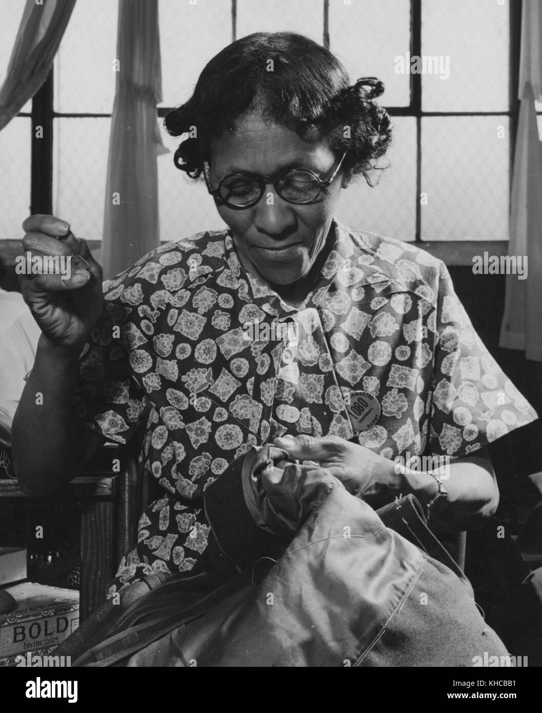 Afroamerikanische Arbeiterin, die Ärmel auf einem Armeemantel im Quartiermeister-Depot handgenäht hat, Mai 1942. Aus der New York Public Library. Stockfoto