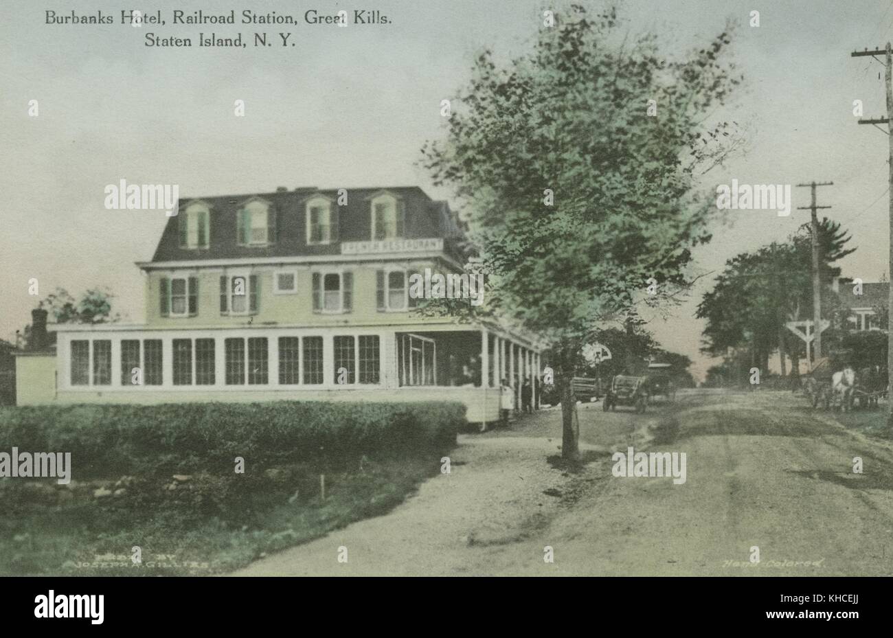 Eine Postkarte von einem getönten Foto des Burbanks Hotel, das dreistöckige Hotel hat ein Schild mit der Aufschrift "French Restaurant", Menschen können auf und um die Veranda zu sehen, Alte Autos und ein Pferdewagen sind entlang der Straße zu sehen, die durch die rechte Seite des Bildes, 1900. Aus der New York Public Library. Stockfoto