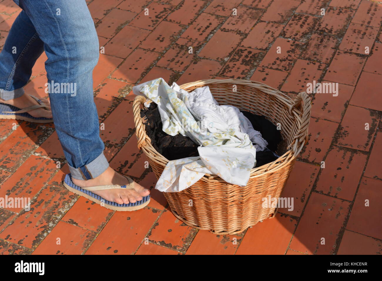 Frau mit einem Weidenkorb der nassen Wäsche, vorbereiten, um in der Sonne zu trocknen Stockfoto
