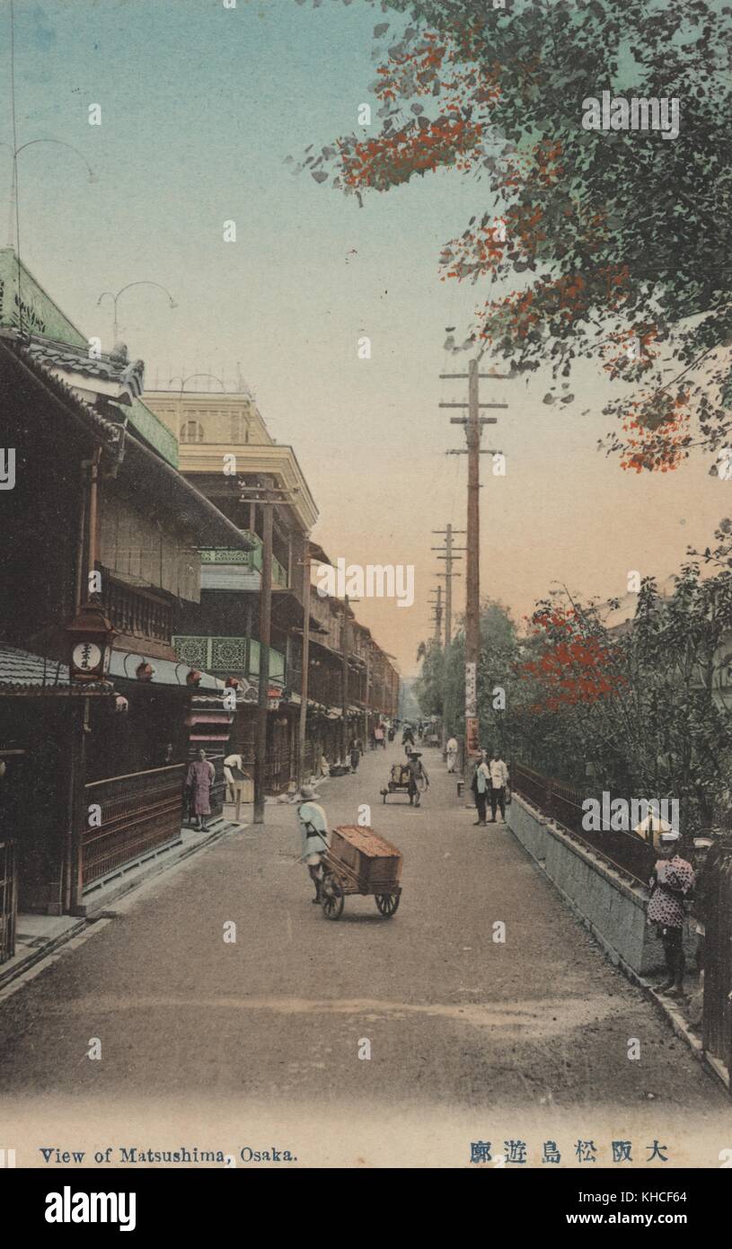 Eine Postkarte von Matsushima, einem für seine Bordelle bekannten Viertel, kann man auf der Straße sehen, während Arbeiter Waren mit handgezogenen Karren transportieren, Osaka, Japan, 1912. Aus der New York Public Library. Stockfoto