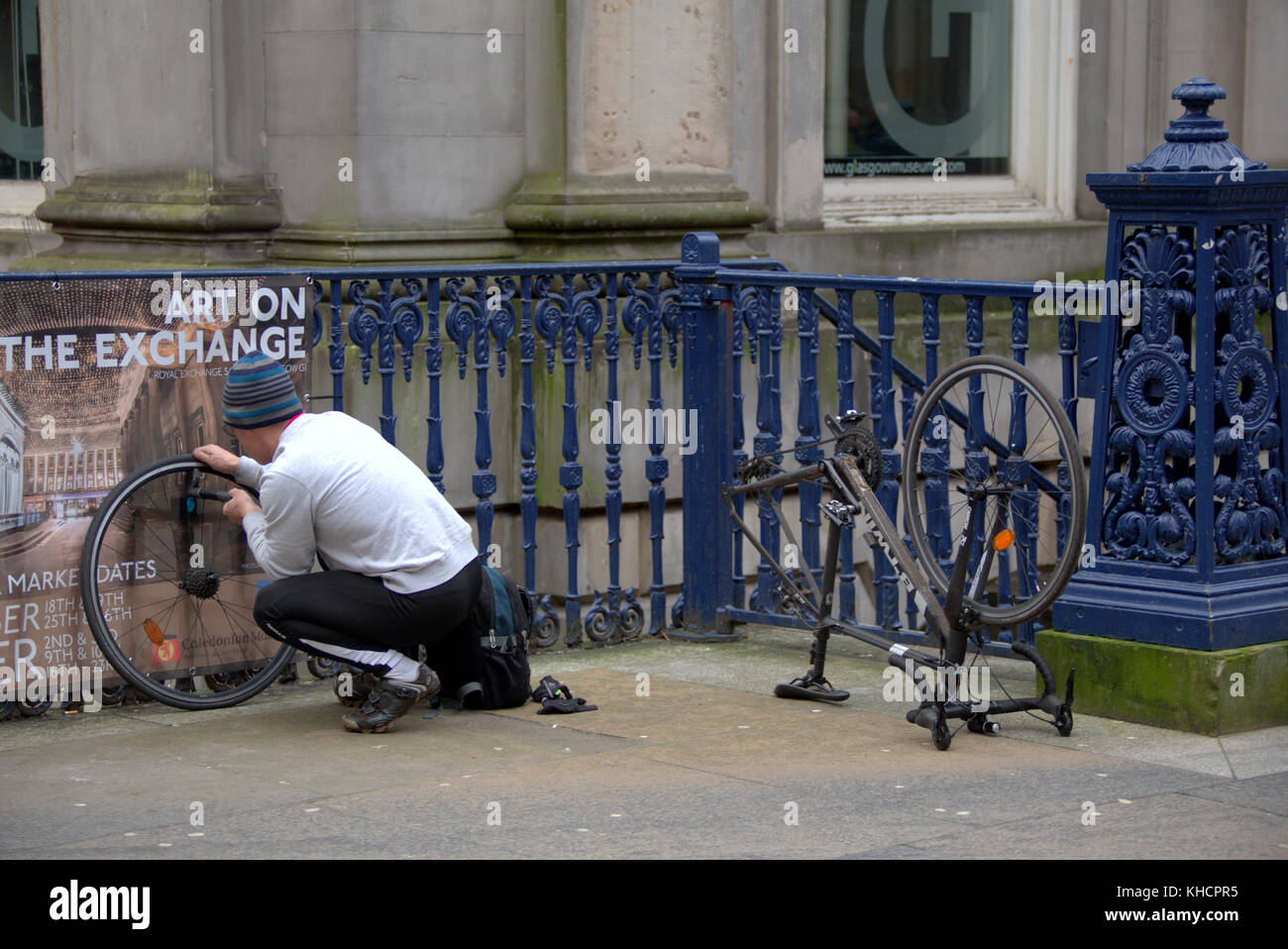 Radfahrer Instandsetzung ein Fahrrad Reifenpanne in Royal Exchange Square Glasgow Goma Stockfoto