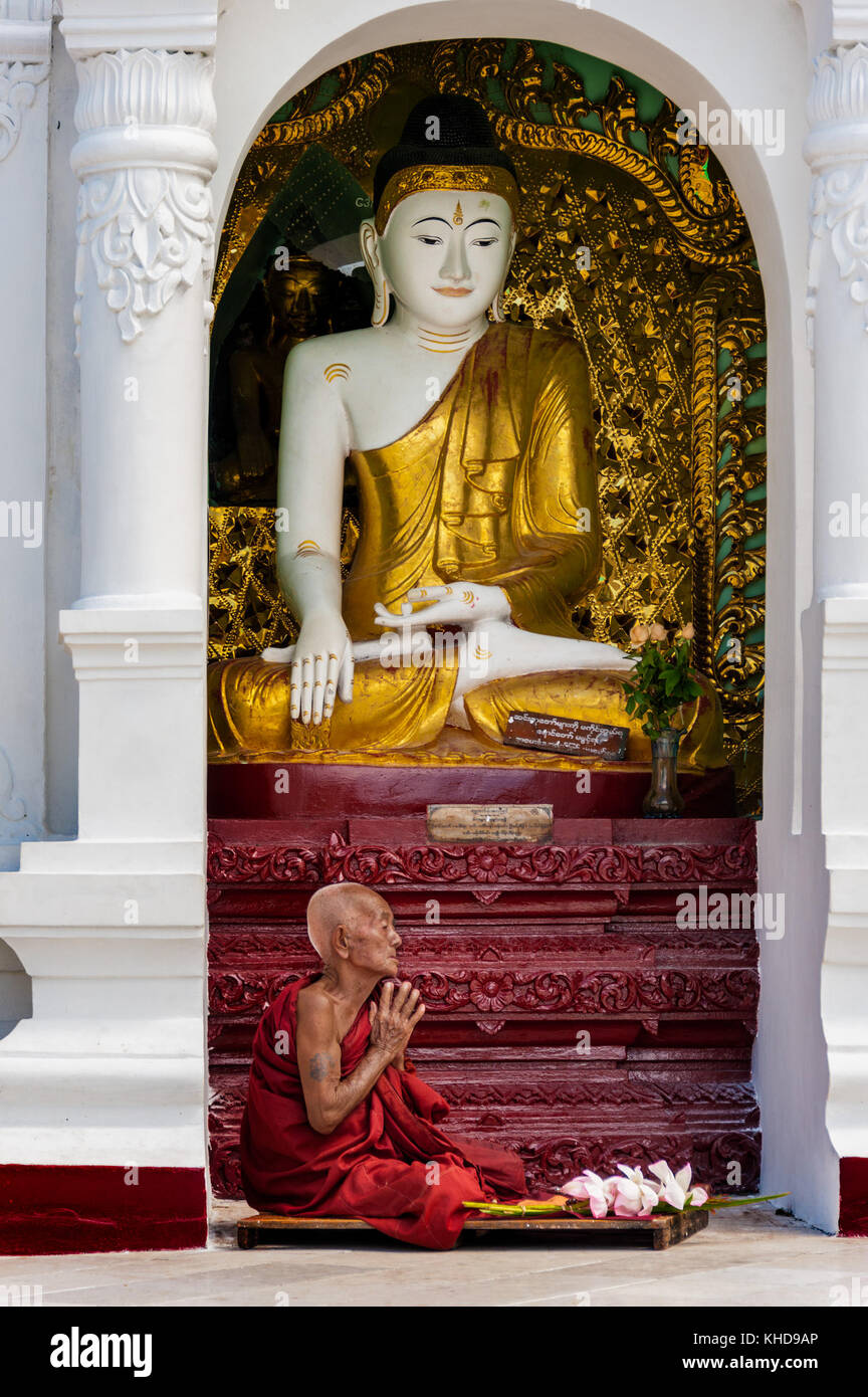 Shwedagon Pagode, Yangon, Myanmar - Oct 21, 2017: Ein buddhistischer Mönch betet zum Herrn Buddha mit Lotus Blumen für bietet. Stockfoto