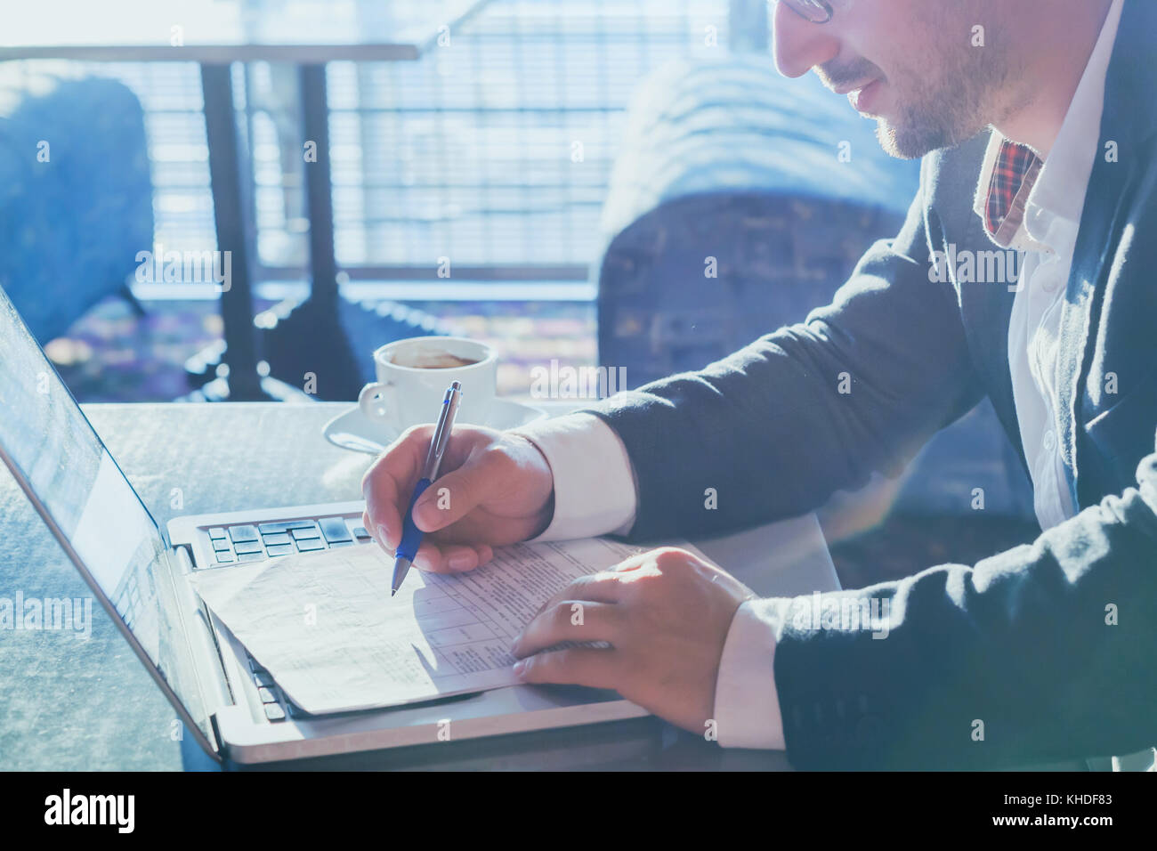 Unternehmer Mann bei der Arbeit mit Computer und Dokumente auf Papier Stockfoto