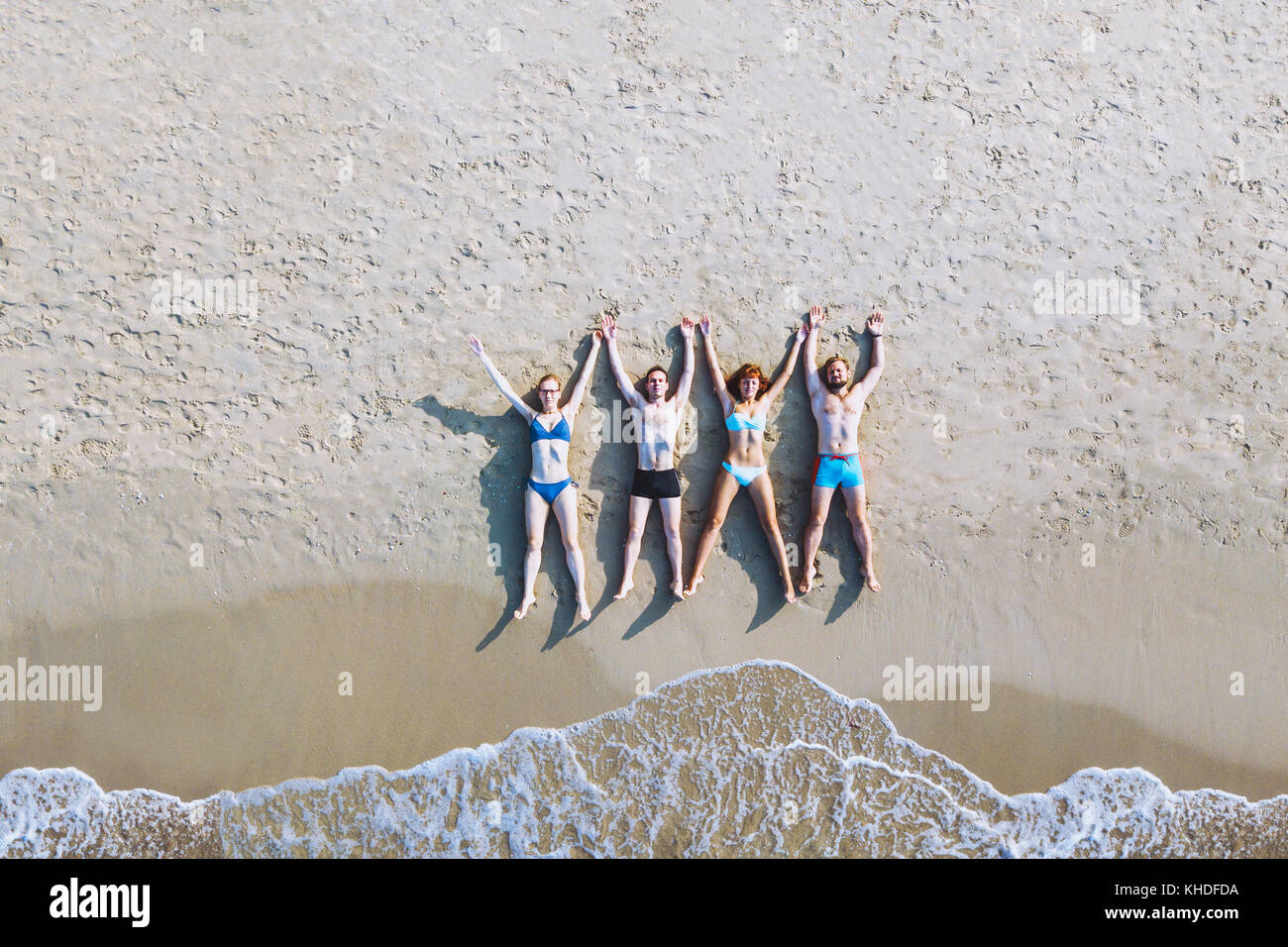 Eine Gruppe von Freunden, die am Strand liegen, tropische Ferien auf dem Meer, Ansicht von oben von drohne von glücklichen Menschen genießen Sommer Reisen Stockfoto