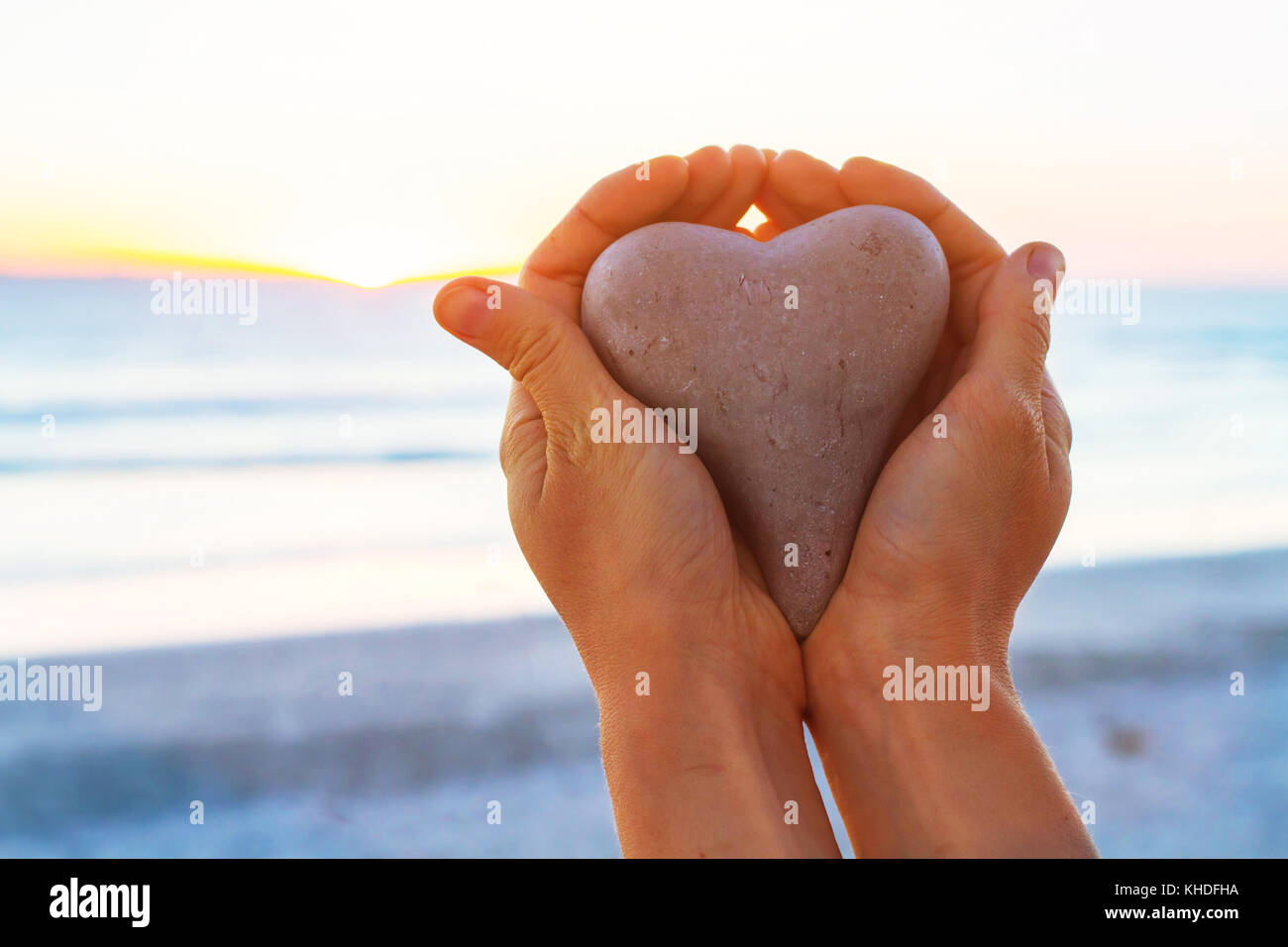 Liebe oder das Konzept, Hände, Herzen Holding im Sunset Beach Stockfoto