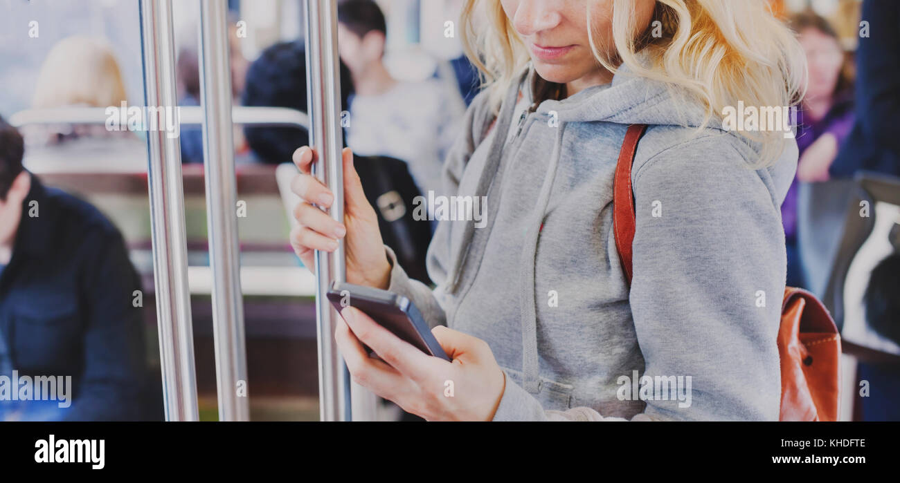 Person auf dem Bildschirm des smart phone in der Nähe der U-Bahn, Frau mit Handy in der U-Bahn Stockfoto