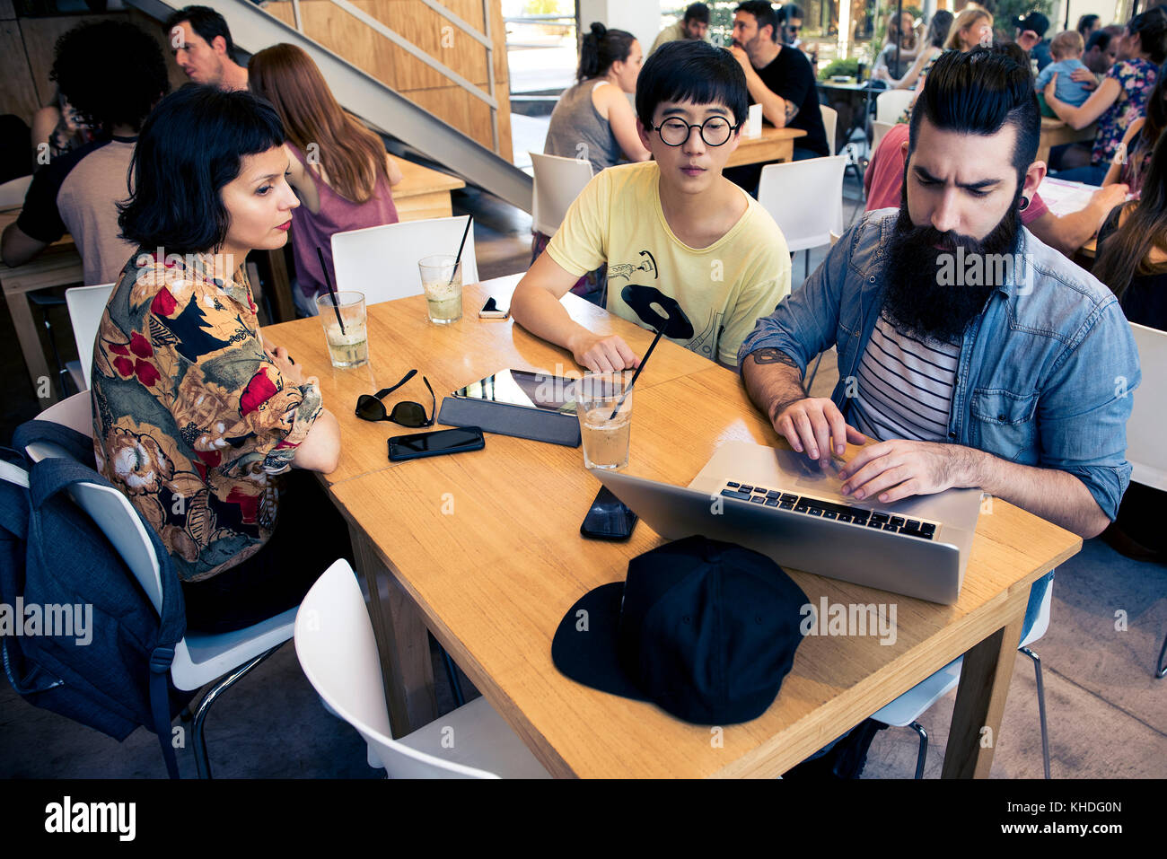 Mann mit Laptop Computer, während Gefährten beobachten Stockfoto