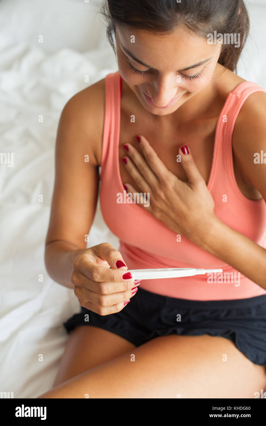 Frau zufrieden mit der Schwangerschaft Test Ergebnisse Stockfoto